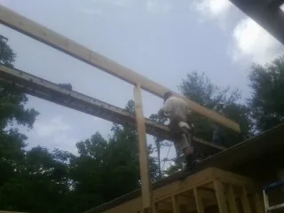 Carpenter setting a ridge beam over a new addition frame — Ice Dam Removal by Roofing Brothers in Holtwood