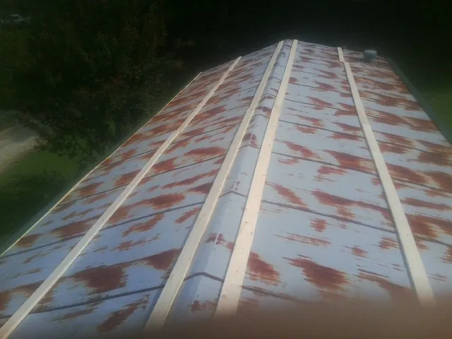 Rusted metal roof panels with new wood purlins before replacement — Storm Damage Roof Repair in Holtwood by Roofing Brothers