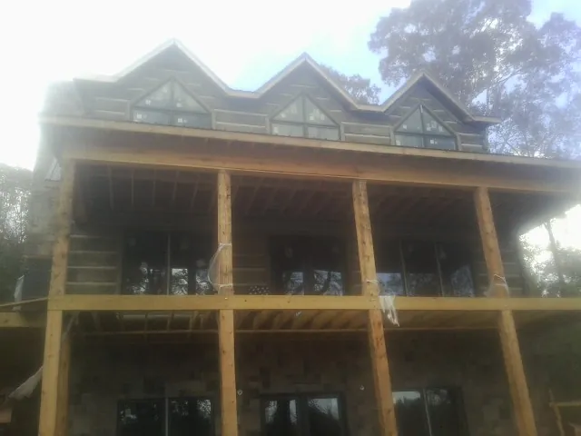 Dormers and porch framing on a large log home under construction — Roof Coating work by our crew in Holtwood