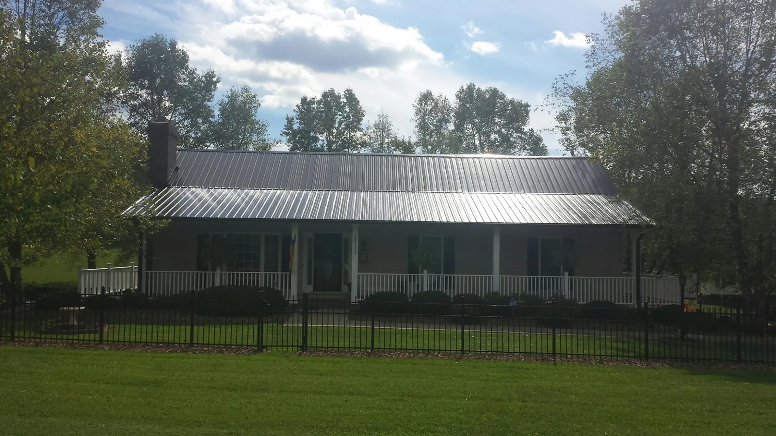 Gray metal roof on a brick ranch with a full width front porch — Gutter Guard Installation work by our crew in Holtwood