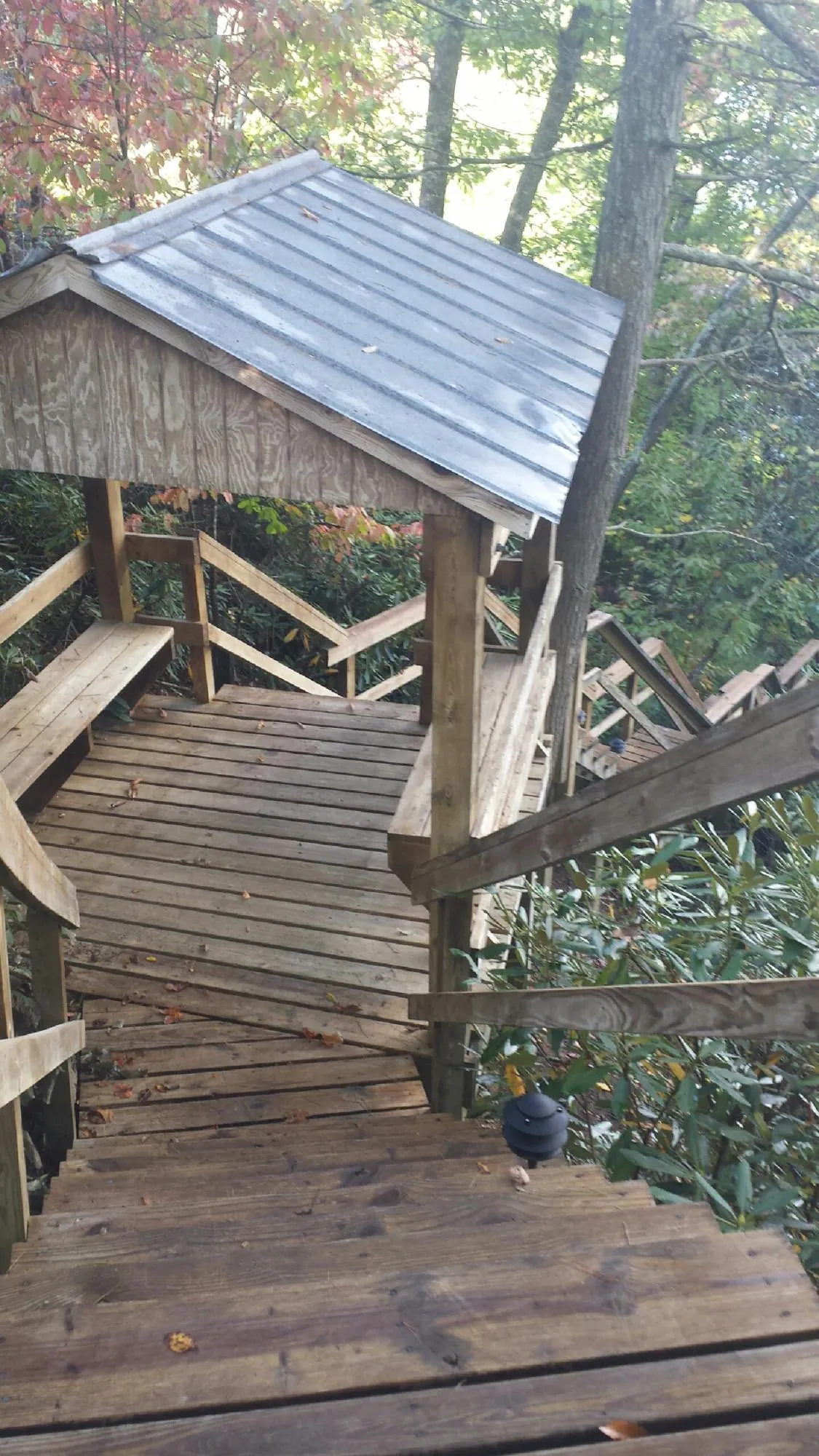 Metal roofed shelter over wooden steps on a wooded walkway — Skylight Repair & Installation work by our crew in Holtwood